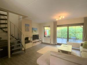 a living room with a staircase and a living room with a couch at Spaanse Galeienstraat 75 in Retranchement