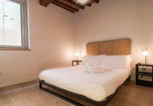 1 dormitorio con 1 cama blanca grande y 2 lámparas en Umbrian Concierge - La Corte del Grillo, en Perugia