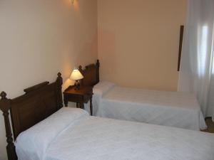 a bedroom with two beds and a table with a lamp at Vivienda tradicional Canaria Saulo 3 in Agüimes