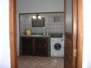 a bathroom with a sink and a washing machine at Vivienda tradicional Canaria Saulo 3 in Agüimes