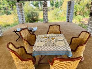 a table with chairs and a table with plates on it at Dera Jawai in Bijāpur