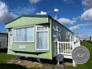 a green tiny house on display in a yard at Seaview - 145 - Ingoldmells in Ingoldmells