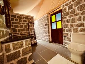 a stone bathroom with a sink and a toilet at Dera Jawai in Bijāpur