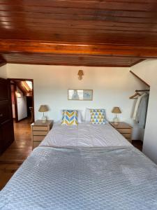 ein großes Bett in einem Zimmer mit Holzdecken in der Unterkunft Foz - Sea View Cottage in Foz do Arelho