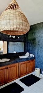 een badkamer met 2 wastafels en een grote kroonluchter bij Ginger Villa Somone in Somone