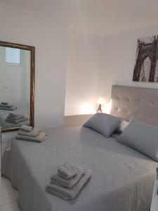 a bedroom with a bed with towels on it at Castle Harbour Home in Los Cristianos