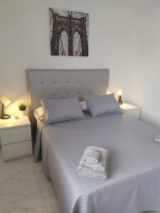 a bedroom with a white bed with a towel on it at Castle Harbour Home in Los Cristianos