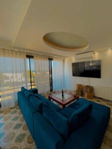 a large blue couch in a living room with a table at Blue View Seaside Luxury Apartments in Ixia