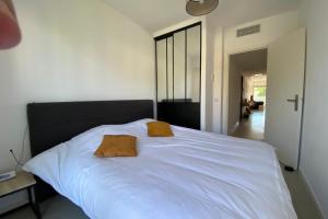 1 cama blanca grande con 2 almohadas marrones en Exceptional Cannes Center sea view and swimming pool LIVE IN PARC BRUYERE, en Cannes 9 fotos más