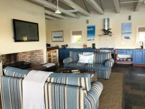 a living room with two couches and a tv at The Boathouse at Oakhurst Olives in Tulbagh