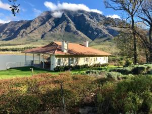 a house with a mountain in the background at The Boathouse at Oakhurst Olives in Tulbagh