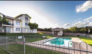 a house with a fence around a swimming pool at The Beacon Fairy in East London