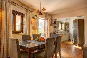 a kitchen and dining room with a table and chairs at Villa Bougainvillea by Villa Plus in Marathias