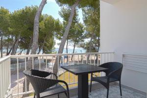 a table and chairs on a balcony with a view of the ocean at Apartamentos Ferrer Lime Playa de Alcudia in Port d'Alcudia