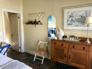 a bedroom with a wooden dresser and a mirror at The Boathouse at Oakhurst Olives in Tulbagh