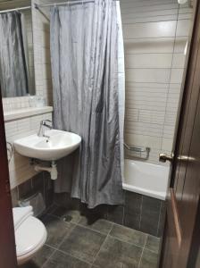 a bathroom with a sink and a shower curtain at Akkotel-Boutique hotel in Acre