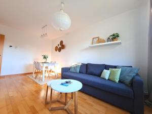 un salon avec un canapé bleu et une table dans l'établissement Dos Torres Las Comarcas - Amplia Terraza y Estacionamiento Gratuito, à Saragosse 42 autres photos