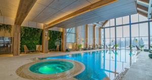 a large swimming pool in a building with a large window at Apartman 34 Razloga in Zlatibor