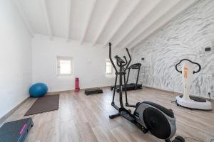 a gym with treadmill and exercise bikes in a room at Can Miquel Porro in Llubí
