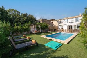 a backyard with a swimming pool and a table and a bench at Can Miquel Porro in Llubí