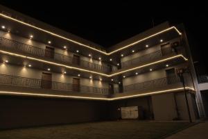 un bâtiment avec des lumières latérales la nuit dans l'établissement The Presidential Suites, à Bhuj