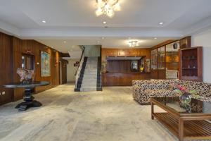 a lobby with a couch and a table and a staircase at Summit Tashi Ghang Heritage Resort in Pelling