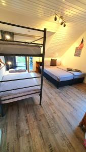 two bunk beds in a room with a wooden floor at FRANKES LODGE Apartment mit Garten, 6 Einzelbetten, Parkplatz in Essen