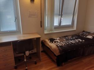 1 dormitorio con escritorio, 1 cama, escritorio y ventana en Glatthall, en Glattbrugg