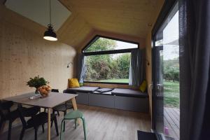 a room with a table and chairs and a window at Wellnester Tiny Houses and Retro-Caravan by the lake in Losheim am See in Losheim