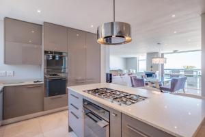 a kitchen with stainless steel appliances and a dining room at Beach Vista by Totalstay in Cape Town