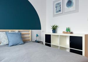sypialnia z łóżkiem z niebieską poduszką w obiekcie Shape&Color premium Hostel w Warszawie
