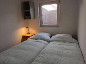 twee bedden in een kamer met een raam bij TINY STUDIO BATAVIA adults only Bed by the Sea in Westkapelle