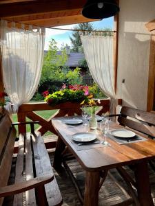 a wooden table with plates and glasses on a patio at Domek Siedlisko Poleski Zakątek in Sosnowica +30 photos