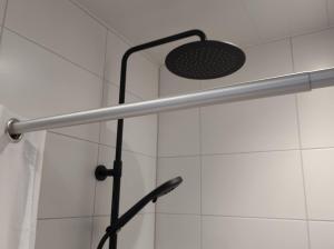 een douche met een paal en een paraplu bij TINY STUDIO BATAVIA adults only Bed by the Sea in Westkapelle