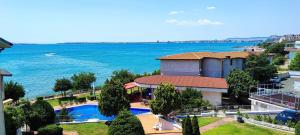 a house with a swimming pool next to the water at Villa Sun Palace in Sveti Vlas
