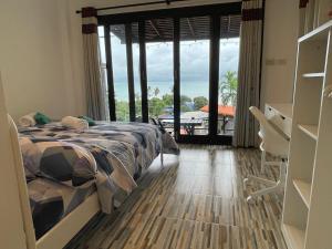 a bedroom with a bed and a view of the ocean at Joy Houses in Haad Rin