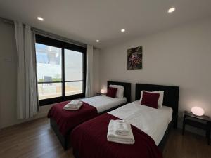 - 2 lits dans une chambre avec une grande fenêtre dans l'établissement Faro Design 5 by Homing, à Faro