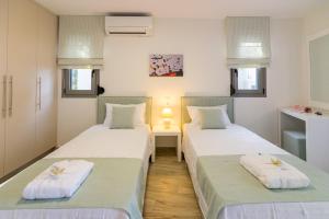 dwa łóżka siedzące obok siebie w pokoju w obiekcie Villa Ilianthos w mieście Panormos +22 zdjęcia
