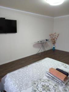 a bedroom with a bed with a flat screen tv at Астана 3 in Oral