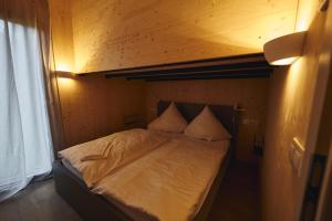 a bed in a small room with at Wellnester Tiny Houses and Retro-Caravan by the lake in Losheim am See in Losheim