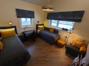 sypialnia z 2 łóżkami, kanapą i oknami w obiekcie MĖTA w mieście Birsztany