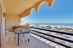 een balkon met een tafel en stoelen en uitzicht op het strand bij Monte Gordo Beachview 2 by Homing in Monte Gordo