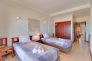 een hotelkamer met 2 bedden en handdoeken erop bij Monte Gordo Beachview 2 by Homing in Monte Gordo