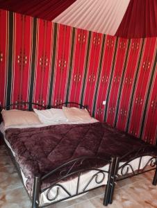 een bed in een kamer met een rode en groene muur bij Sunset Mountain in Wadi Rum