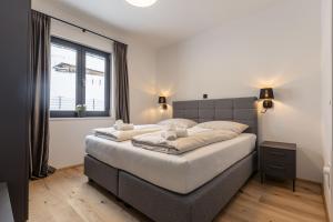 a bedroom with a large bed and a window at Hideaway Dachstein West by ALPS RESORTS in Sankt Martin am Tennengebirge