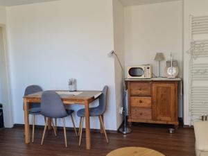 mesa de comedor con 2 sillas y microondas en Ferienwohnung Forsthaus, en Bad Grönenbach