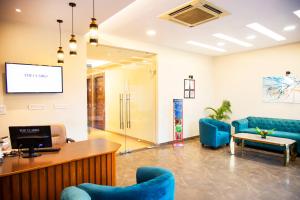 a waiting room with blue chairs and a table at Clarks Inn Dudhwa in Paliā Kalān