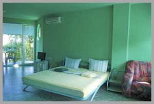 a bedroom with a bed and a chair at The Colourful Mansion Hotel in Ahtopol