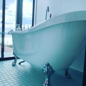W łazience z oknem znajduje się biała wanna. w obiekcie Kamiamakusa - House - Vacation STAY 54914v w mieście Kami Amakusa