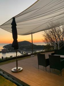 un tavolo e sedie sotto un ombrellone bianco su una terrazza di Kamiamakusa - House - Vacation STAY 54914v a Kami Amakusa